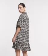 Vestido corto en viscosa con estampado de pinceladas en tonos negro, verde y blanco. Tiene cuello solapa, mangas cortas, abotonado delantero y volado en el bajo.