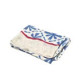 Pashmina de textura suave con estampado geométrico y floral en tonos azules sobre fondo beige, con detalles de líneas rojas en los bordes.