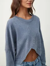 Buzo manga larga color celeste con diseño irregular y corte crop.