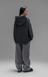 Hoodie oversize de algodón con efecto desgastado, costuras expuestas y roturas decorativas. Presenta capucha, bolsillo frontal tipo canguro y terminaciones deshilachadas.