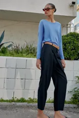 Pantalón tobillero azul marino de tiro medio, con pinzas delanteras, bolsillos frontales, falsos bolsillos con solapa en la espalda y cierre frontal con cremallera, botón y gancho. Incluye cinturón de cuero sintético tostado con hebilla metálica dorada.