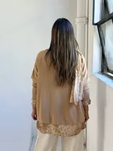 Sweater de punto color arena con diseño de capas que incluye una camisa inferior y un pañuelo a juego, ambos con estampado animal print en tonos tierra.