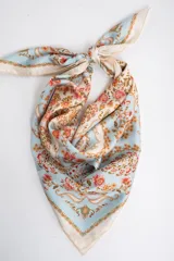 Pañuelo cuadrado de poliéster con estampado tipo paisley y floral en tonos celestes, blancos, rosados y anaranjados.