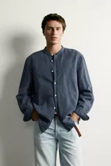 Camisa de corte relajado, confeccionada en mezcla de lino y algodón. Presenta cuello tipo mao, manga larga con puño abotonado y cierre frontal con botones.
