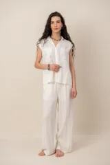 Conjunto de blusa sin mangas con bolsillos frontales y pantalón de corte holgado, color blanco.