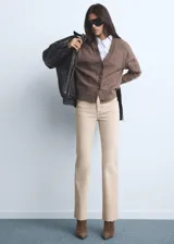 Jeans tiro medio color beige con diseño flare y bajo deshilachado, con cierre de cremallera y botón, trabillas y cinco bolsillos.
