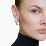 Aros tipo argolla con forma de corazón abierto, con circonitas Swarovski transparentes engarzadas en talla baguette y baño de rodio.