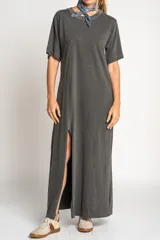 Vestido largo gris oscuro de algodón, con cuello redondo y mangas cortas. Presenta un tajo lateral alto.