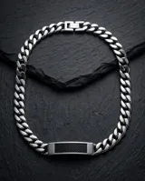 Pulsera de eslabones tipo cubana fabricada en acero inoxidable, con una placa central decorada con un inserto de fibra de carbono.