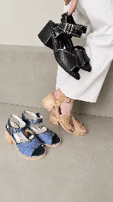 Sandalias de cuero combinadas en azul y negro, con diseño de textura croco en la capellada, costuras en contraste y taco ancho de madera. Poseen tira al tobillo con hebilla metálica regulable.