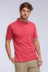 Remera polo de piqué de manga corta, color rojo, con cuello y cierre frontal de dos botones. Cuenta con un pequeño logo bordado en el pecho.