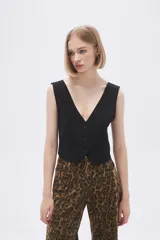 Top tipo chaleco de corte entallado, con escote en V y cierre frontal con botones a tono.