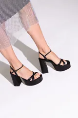 Sandalias de cuero sintético color manteca, con plataforma y tacón bloque. Presentan tiras cruzadas en el empeine y pulsera con hebilla al tobillo.