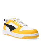 Championes Puma Rebound V6 Low de estilo urbano, con diseño de bloques de color en amarillo, blanco y negro. Presentan una parte superior de cuero sintético con perforaciones en la puntera, cierre de cordones y suela de goma con amortiguación en el talón.