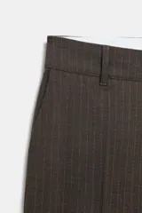 Pantalón de tiro medio con diseño de raya diplomática, corte recto y cintura con trabillas. Cuenta con bolsillos laterales, bolsillos traseros de vivo y cierre frontal con cremallera, botón y ganchos metálicos.