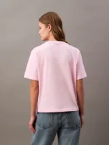 Remera rosa de algodón con cuello redondo y mangas cortas con dobladillo. Estampado de flor celeste en el frente y logo de Calvin Klein.