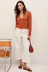 Cardigan cropped de punto calado color tostado, con escote en V, manga larga y cierre frontal con botones.