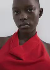 Top rojo de punto fino, con cuello halter drapeado, diseño recto y sin mangas.