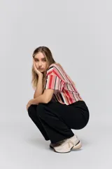 Babucha de calce relajado color negro, con cintura elastizada, cordón de ajuste y bolsillos laterales. Presenta un diseño de pernera amplia y cómoda.