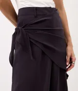 Pantalón wide leg negro de viscosa, con piernas amplias, caída fluida y detalle de pañuelo cruzado con atadura lateral en la cintura.