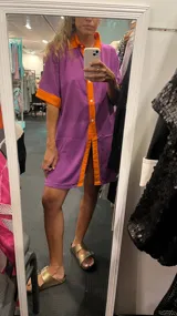 Conjunto de camisa de mangas cortas y short, color lila con detalles en naranja en cuello, mangas y ruedo.