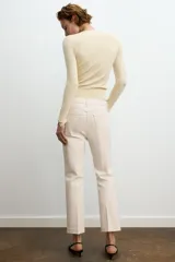 Jeans de mezclilla azul claro, tiro medio, corte recto y ligeramente acampanado en el bajo. Presenta cinco bolsillos y cierre frontal con cremallera y botón metálico.