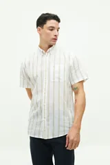 Camisa de manga corta confeccionada en lino y algodón, con fit regular y logo bordado. Color beige con rayas verticales blancas.