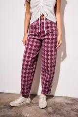 Jean de corte baggy y tiro medio, con estampado de rombos en tonos violeta y borravino. Presenta diseño de cinco bolsillos y cierre frontal con botón y cremallera.