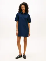 Vestido tipo chomba azul marino de manga corta, con cuello camisero, cartera de tres botones y logo script bordado en el pecho.