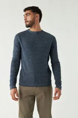 Sweater azul de punto con cuello redondo, mangas largas y logo bordado en el pecho. Corte slim fit.