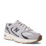 Championes New Balance 530 de estilo running retro, en tonos gris claro y lila suave, con detalles en blanco y suela de goma marrón.