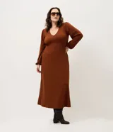 Vestido midi de punto acanalado color marrón, con escote en V y mangas largas abullonadas. Presenta un diseño ajustado en el torso que se ensancha suavemente hacia el ruedo.