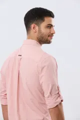 Camisa celeste de manga larga confeccionada en algodón, con cuello camisero, cierre frontal de botones, bolsillo en el pecho y diseño de cuadros sutiles.