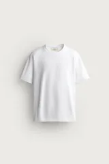 Camiseta regular fit de color beige, confeccionada en tejido de algodón compacto, con cuello redondo y manga corta.