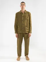 Chaqueta verde oliva de lino italiano, corte relajado, con tres bolsillos frontales y cierre con botones.