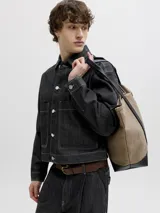Chaqueta de denim negro con costuras en contraste color blanco, bolsillos frontales con solapa y cierre de botones metálicos.