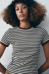 Camiseta de manga corta con estampado de rayas horizontales blancas y negras, cuello redondo y ribetes en color marrón.