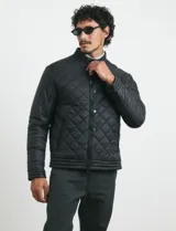 Campera capitoneada de color azul oscuro, con cierre frontal de metal y botones a presión. Presenta bolsillos laterales y en el pecho con cierres metálicos.