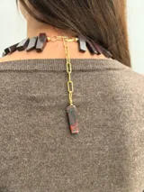 Collar de jaspe rojo natural en tonos bordeaux y rojo profundo, con piezas rectangulares dispuestas en fila y cadena de extensión dorada con dije colgante.