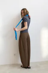 Pantalón de tiro alto con diseño balloon, presenta pliegues frontales, trabillas para cinturón, bolsillos laterales y cierre frontal con cremallera y botón.