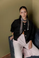 Bomber de corte corto y silueta relajada, confeccionada en paño de lana con cashmere. Presenta cuello redondo, cierre frontal con botones y mangas con puños elásticos.