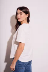 Remera blanca de manga corta con cuello redondo y textura de líneas horizontales con perforaciones.