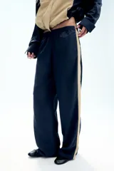 Pantalón de tiro medio azul marino con cintura elástica y bandas laterales en tono tostado a contraste, con diseño de pierna ancha.