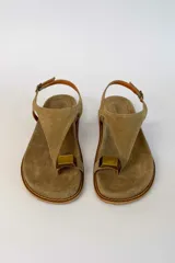 Sandalias de gamuza color tostado, con tira de dedo, hebilla ajustable en el talón y detalle metálico dorado.