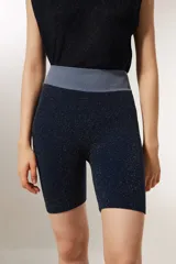 Short de calce alto, color azul marino con lurex dorado y cintura elástica gris.