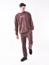 Pantalon de jogging negro con cintura elástica y cordón ajustable. Presenta un pequeño logo circular estampado en la pierna izquierda y bolsillos laterales.