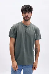 Remera de manga corta color verde, con cuello mao y botones en la parte frontal.