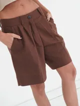 Bermuda color marrón con tiro medio, bolsillos laterales y un ojal en la parte trasera. Presenta un bordado en la pretina posterior.