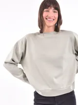 Buzo de corte holgado color rosa viejo, con cuello redondo y mangas largas.