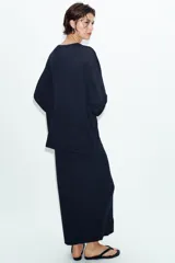 Jersey de punto fino con diseño oversize, cuello redondo y manga larga.